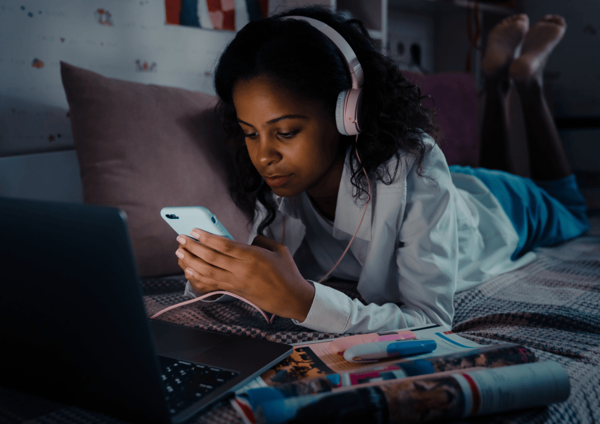 black youth on cell phone listening to headphones